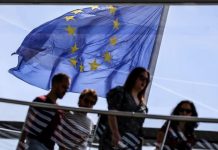 The European Union flag flies in the wind as visitors pass by at the observatory dome of the Reichstag in Berlin, Germany, May 19, 2022. OMER MESSINGER, EPA-EFE/FILE