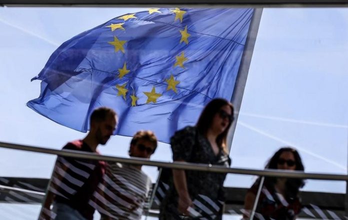 Trade_chief_-_EU.JPG_resized The European Union flag flies in the wind as visitors pass by at the observatory dome of the Reichstag in Berlin, Germany, May 19, 2022. OMER MESSINGER, EPA-EFE/FILE