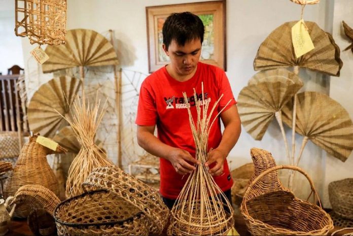 buy_local.JPG_resized Jessie Arenas arrange furniture made of various indigenous materials inside a shop in Villaba, Leyte. BASILIO SEPE / OXFAM PILIPINAS PHOTO