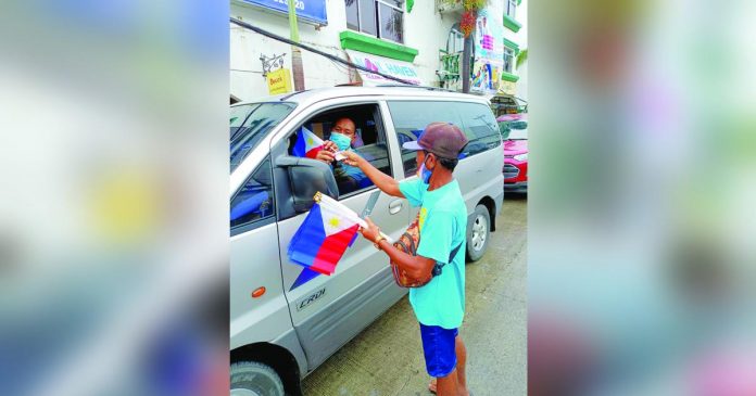 flag vendors_superimposed Ernesto Magsino said, beyond income, he sells Philippine Flags to show his loyalty to the country and to remind his fellow Ilonggos of the significance of Independence Day. AJ PALCULLO/PN