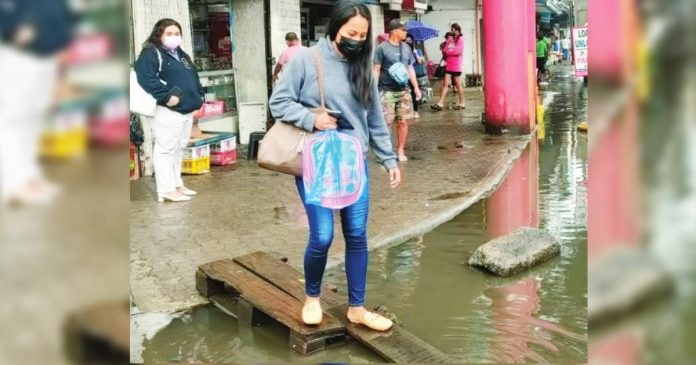 Pedestrians balance off wooden planks to avoid wading into floodwaters. Intermittent, heavy rains since Tuesday night, May 30, until Wednesday, May 31, inundated Ledesma Street, Iloilo City. AJ PALCULLO/PN