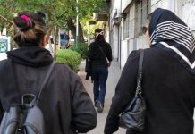 Iran women defy hijab law Two women walk down a street, facing away from the camera – one is wearing a headscarf and one is not. Some women in Iran are choosing not to cover their hair as part of ongoing protests. HANDOUT