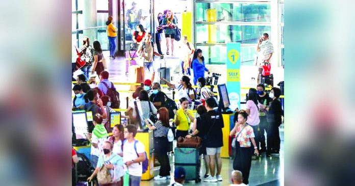 overbooking_flights.JPG_superimposed_resized Travelers line up at airline counters to process their travel documents at the Ninoy Aquino International Airport Terminal 3 in Pasay City. JONATHAN CELLONA/ABS-CBN NEWS PHOTO