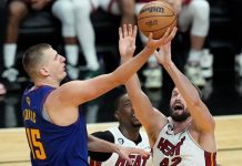 Denver Nuggets’ Nikola Jokic (left) secures the ball from Miami Heat rivals. AP