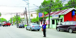 A traffic aide directs the flow of vehicles in Barangay Baluarte, Molo, Iloilo City on Tuesday, June 6. Mayor Jerry Treñas issues a final warning to traffic aides: those caught smoking, texting or gossiping while on duty will immediately be dismissed from the service. AJ PALCULLO/PN