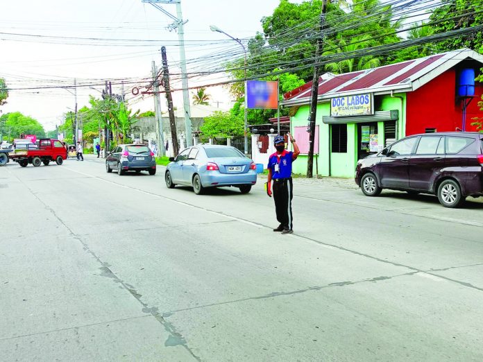 traffic_aide_pic_resized A traffic aide directs the flow of vehicles in Barangay Baluarte, Molo, Iloilo City on Tuesday, June 6. Mayor Jerry Treñas issues a final warning to traffic aides: those caught smoking, texting or gossiping while on duty will immediately be dismissed from the service. AJ PALCULLO/PN