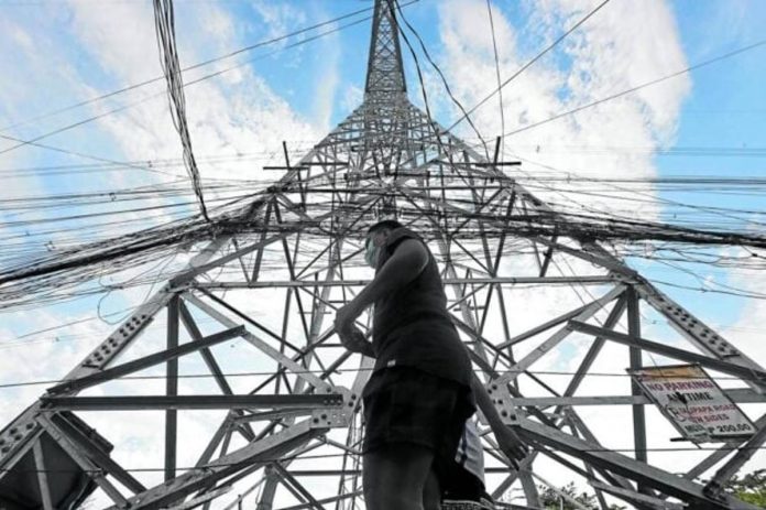 NGCP_resized A pedestrian walks past a transmission tower of the National Grid Corp. of the Philippines. INQUIRER FILE PHOTO