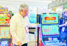 Philippine Amusement and Gaming Corporation chairman and CEO Alejandro Tengco inspects a modern slot machine which was exhibited at the SiGMA Asia Summit 2023 in Pasay City.