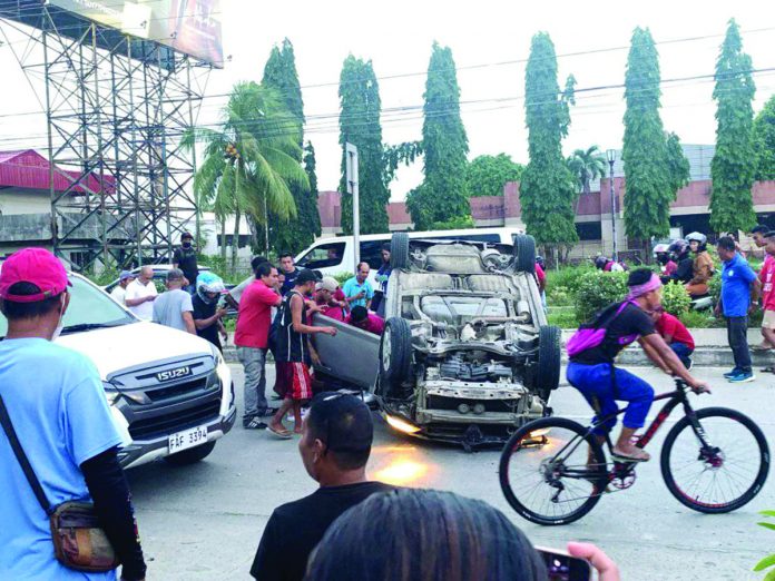 car_overturns_resized A Honda City Sedan overturned after hitting a vehicle and the center island in Barangay Ungka, Pavia, Iloilo on Friday, July 7. RADYO BANDERA ILOILO PHOTO