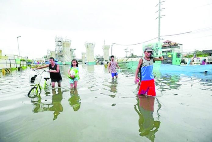 egay_resized MORE FLOODS. Residents in Marilao town in Bulacan province wade through its flooded streets near pillars for the overhead MRT 7 rail line on Saturday. The weather bureau warns of more rains in the coming days from Tropical Storm “Falcon” (international name: Khanun), which is now east of Luzon over the Philippine Sea. PHOTO BY LYN RILLON / PHILIPPINE DAILY INQUIRER