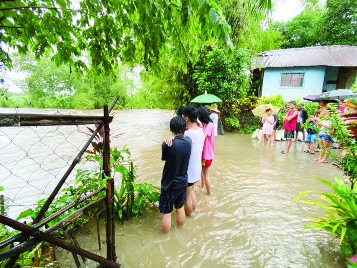 habagat_resized Residents of Barangay Ma-ao, Bago City wait for the flood to subside. The city is among the local governments in Negros Occidental affected by the inclement weather. BARANGAY MA-AO COMMUNITY FACEBOOK PHOTO