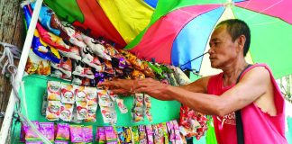 Vendors Eddie Laisac and Rochelle Bama fear losing customers if junk food and sweetened drinks get pricier. AJ PALCULLO/PN