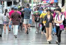 Pedestrians, many of them wearing face masks, cross Kamuning Road in Quezon City in this file photo. File photo by GRIG C. MONTEGRANDE / Philippine Daily Inquirer