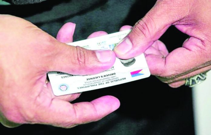 nation_pic_resized LICENSE CARDS. A staff of the Land Transportation Office shows a brand new student driver’s license at the Land Transportation Office Quezon City District Office in Centris Station. INQUIRER PHOTO/LYN RILLON