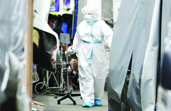 DOH_resized A medical worker at a hospital in Mandaluyong City checks COVID admissions. NIÑO JESUS ORBETA, PHILIPPINE DAILY INQUIRER