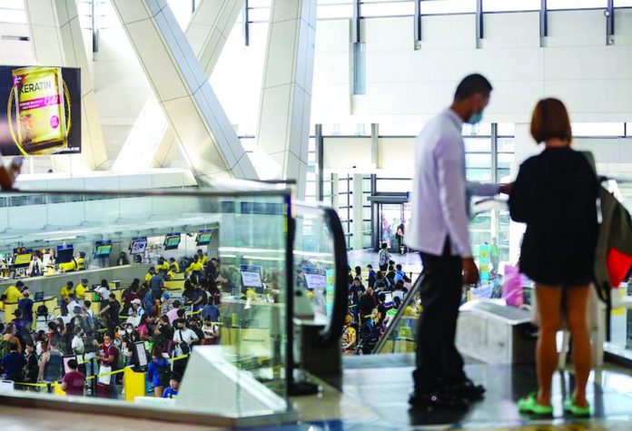 Travelers line up at airline counters to process their travel documents at the Ninoy Aquino International Airport Terminal 3 in Pasay City. JONATHAN CELLONA/ABS-CBN NEWS PHOTO