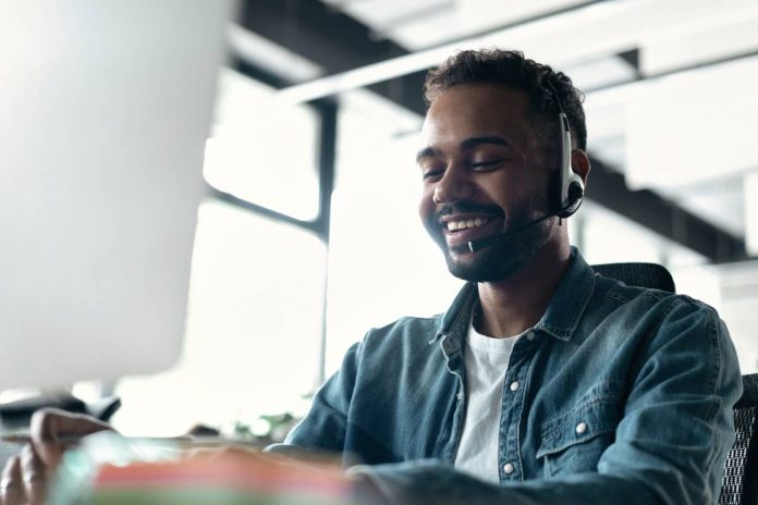 Happy young male customer support executive working in office.
