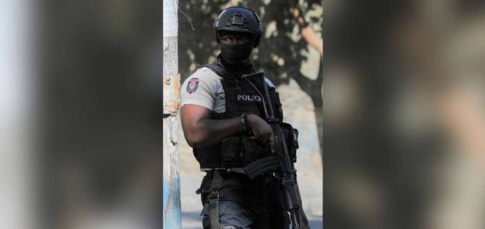 A police officer stands guard near a site where alleged gang members were set on fire by a crowd of people in Port-au-Prince, Haiti. REUTERS