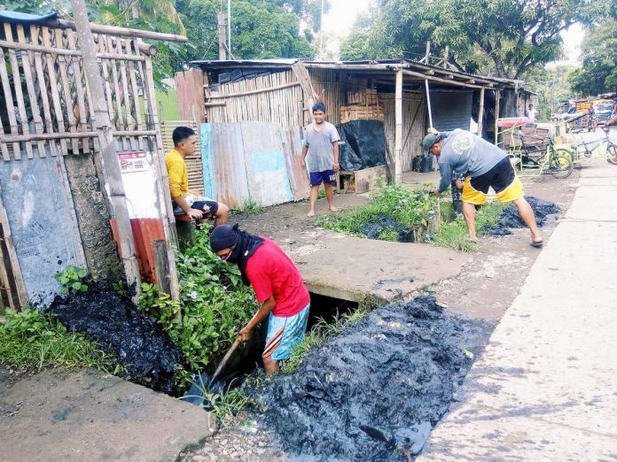 leptos_resized Humans can become infected with leptospirosis if they come into contact with contaminated water, soil, or even food. Photo shows residents conducting a cleanup drive in Iloilo. PN FILE PHOTO