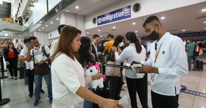 vax_cert_resized Airport personnel check the passport of passengers at the Ninoy Aquino International Airport in this undated photo. The Department of Health says arriving international travelers are now allowed entry regardless of their vaccination status for the coronavirus disease 2019. PNA PHOTO BY YANCY LIM