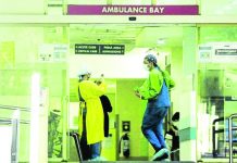Emergency room personnel share a light moment at the ambulance bay of the Makati Medical Center. FILE PHOTO