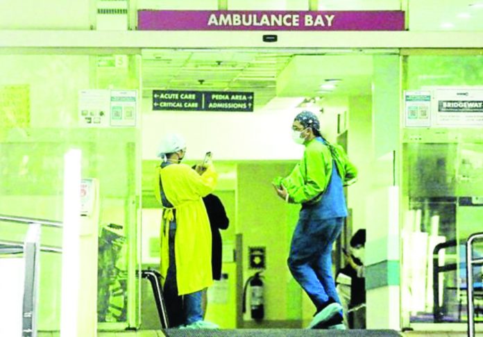 hospitals_resized Emergency room personnel share a light moment at the ambulance bay of the Makati Medical Center. FILE PHOTO