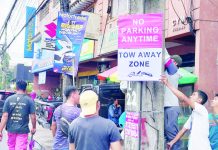 Personnel of the Bacolod Traffic Authority Office install signages in designated tow-away zones on Lacson Street, Bacolod City on Monday, Sept. 25. BTAO