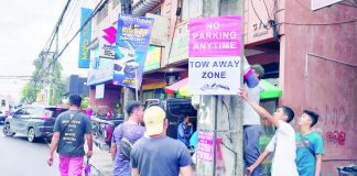 Personnel of the Bacolod Traffic Authority Office install signages in designated tow-away zones on Lacson Street, Bacolod City on Monday, Sept. 25. BTAO
