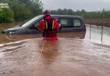 Firefighters help a man leave his vehicle trapped in floodwaters in Spain’s Castelló province. REUTERS