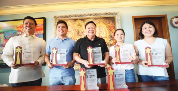 banner_pic_resized BIGGEST WINNER. Iloilo City’s Mayor Jerry P. Treñas (center), along with Rep. Julienne Baronda (2nd from right), Councilor Jose Miguel Treñas (2nd from left), and Executive Assistants Jay Treñas and Raisa Treñas (leftmost and rightmost, respectively) hold with pride the city’s seven awards from the recent Philippine Creative Cities and Municipalities Competitiveness Congress.