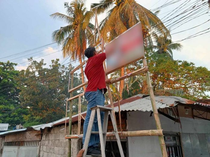 campaign_posters_blur Jonathan Sayno, Election Assistant II of the Commission on Elections-Iloilo City, leads the removal of illegal campaign posters in Arevalo district. AJ PALCULLO/PN