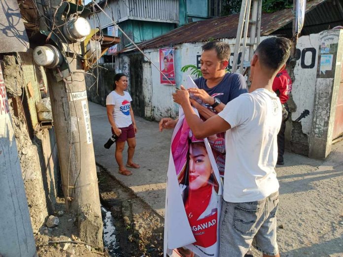 Members of “Operation Baklas” of the Commission on Elections-Iloilo City remove campaign posters illegally posted on electrical post in Molo district. PN FILE PHOTO