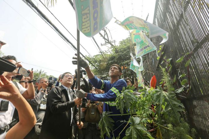 comelec_resized Commission on Elections chairperson George Erwin Garcia (center) leads the “Operation Baklas” (dismantling) of illegal campaign materials of Barangay and Sangguniang Kabataan Elections candidates along Oroquieta Street corner Recto Avenue in Manila. Most of the campaign materials removed are hanging from electric posts and wires. PNA