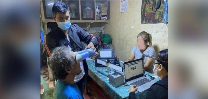 edited news jen ID_superimposed A senior citizen of Guimaras has his eyes scanned for his national ID. A personnel of the Philippine Statistics Authority is assisting him. PSA-GUIMARAS