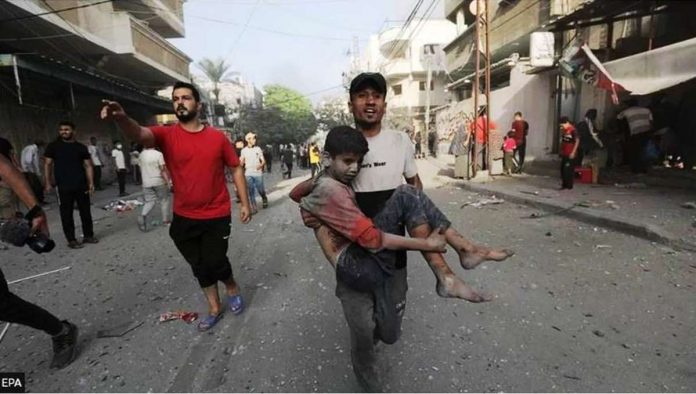 gaza_resized A Palestinian man carries a wounded boy following an Israeli air strike in northern Gaza. EPA