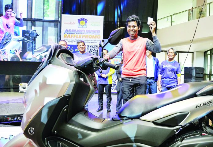 Delivery rider Joseph Talaroc (center) displays the brand new motorcycle he won during the Pag-IBIG Asenso Rider Raffle Promo Launch in Pasay City earlier this year. Talaroc is one of the over 13,000 delivery riders who are now members and have joined the agency’s raffle promo. Joining him are (from left, partially hidden) DOLE Undersecretary Ciriaco Lagunzad III, Pag-IBIG Deputy CEO Alexander Aguilar, Pag-IBIG Trustees Gregorio Montenegro and Ma. Lorelei Fajardo, Housing Secretary and Pag-IBIG Fund Chairman Jose Rizalino Acuzar, and Pag-IBIG CEO Marilene Acosta.