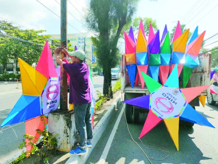 parols_pic_resized Iloilo City Engineer’s Office personnel install rainbow Christmas parols on the city’s major streets. AJ PALCULLO/PN