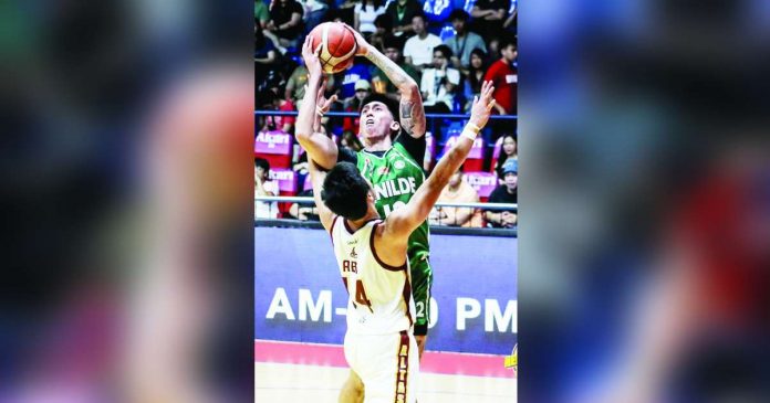 sports csb_superimposed Negrense Miggy Corteza of the College of St. Benilde Blazers goes for a tough basket against a University of Perpetual Help Altas defender. PHOTO BY NCAA/GMA SPORTS