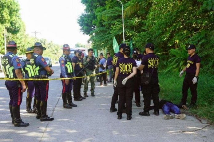 barangay_resized Police gather evidence beside bodies at the scene of a shooting outside a polling station following a confrontation between supporters of rival candidates, during the nationwide village and youth representative elections in Datu Odin Sinsuat town on Mindanao island on Oct.30, 2023. PHOTO BY FERDINANDH CABRERA / AFP