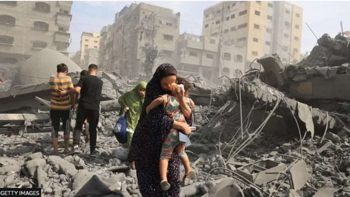 gaza_resized A Palestinian woman secures her child amid the rubbles of a residential building destroyed by Israeli airstrike in the Gaza Strip. GETTY IMAGES