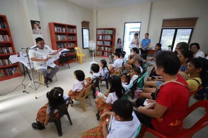 libraries_resized Mayor Jerry Treñas reads a story to daycare children during the inauguration of Nabitasan Reading Center in Barangay Nabitasan, La Paz, Iloilo City on Nov. 9. ILOILO CITY GOVERNMENT PHOTO