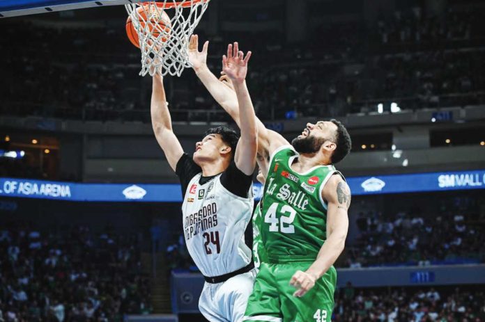 University of the Philippines Fighting Maroons’ Sean Torculas and De La Salle University Green Archers’ Ben Phillips battle for the rebound. UAAP PHOTO