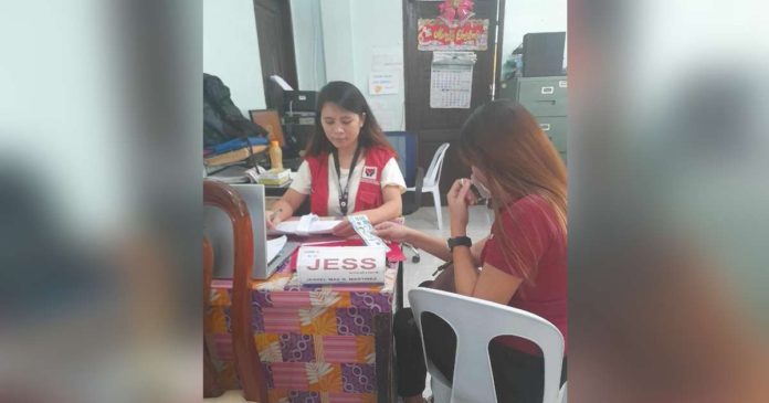 P220K aid_superimposed An employee of the Department of Social Welfare and Development Region 6 facilitates the releasing of cash assistance to the family of one of the victims of the tragic bus accident in Barangay Igbucagay, Hamtic, Antique. DSWD-6 PHOTO