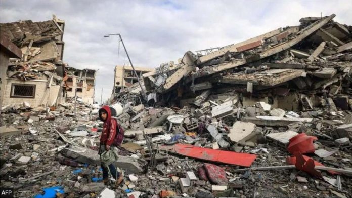 A Palestinian boy walks past destroyed buildings in the central Gaza Strip. AFP