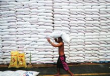 A worker carries a sack of rice on his head inside a government rice warehouse National Food Authority in Quezon City. REUTERS/ERIK DE CASTRO/FILES