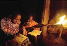 Children study at night using a flame on a stick in their manyatta [mud-thatch home] at Kisima in Samburu County, approximately 350 kilometers north of Nairobi, Kenya. AFP