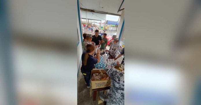 Personnel of the Philippine Coast Guard Auxiliary's 618th Squadron serve hot food and drinking water to stranded passengers at the BREDO Port in Bacolod City on Monday afternoon, Dec. 17. PCG-NEGROS OCCIDENTAL PHOTO