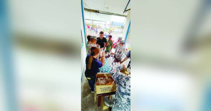 passengers_superimposed Personnel of the Philippine Coast Guard Auxiliary's 618th Squadron serve hot food and drinking water to stranded passengers at the BREDO Port in Bacolod City on Monday afternoon, Dec. 17. PCG-NEGROS OCCIDENTAL PHOTO