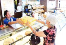 A customer claims her order from a bakery in Sampaloc, Manila in this file photo. The Asosasyon ng Panaderong Pilipino's leadership on Thursday, Dec. 14, said only select flour-based items may see price movements this holiday season. PNA PHOTO BY ROBERT OSWALD P. ALFILER