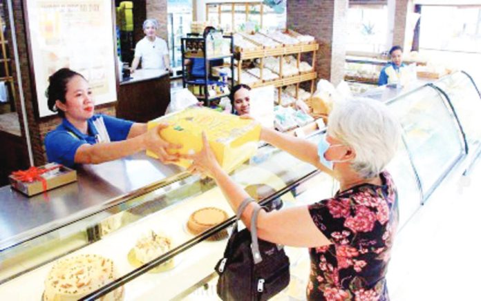 stable_prices_resized A customer claims her order from a bakery in Sampaloc, Manila in this file photo. The Asosasyon ng Panaderong Pilipino's leadership on Thursday, Dec. 14, said only select flour-based items may see price movements this holiday season. PNA PHOTO BY ROBERT OSWALD P. ALFILER